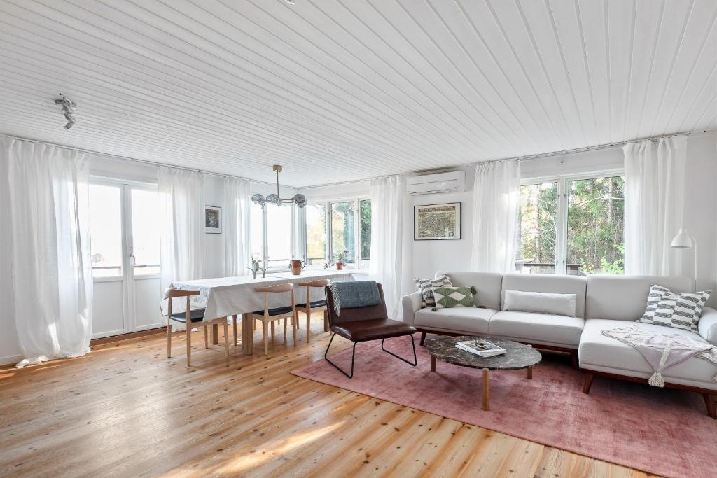 een woonkamer met een bank en een tafel bij Peaceful family home with indoor fireplace in Åkersberga