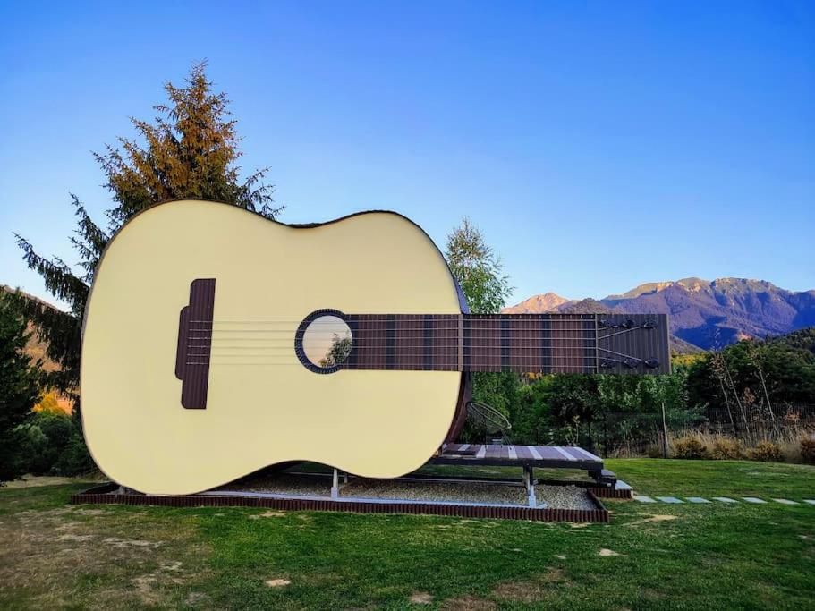 eine große Gitarrenstatue in einem Park in der Unterkunft Guitar House - Symphony Resort in Râșnov