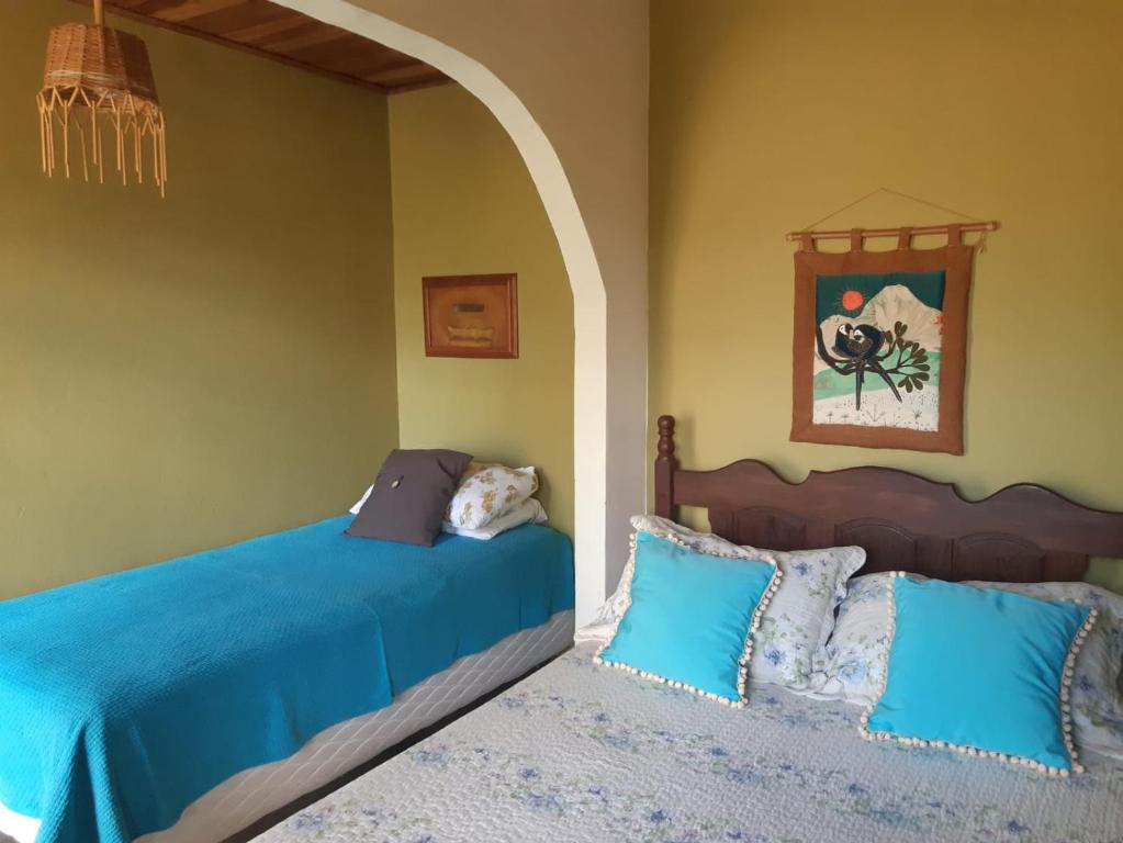 a bedroom with two beds with blue sheets at Pousada Manacás in Cavalcante