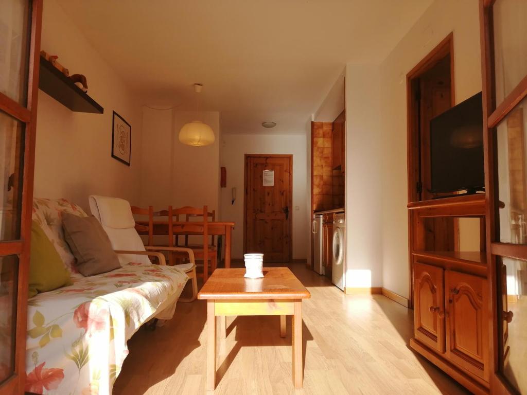 ein Wohnzimmer mit einem Sofa und einem Tisch in der Unterkunft Apartaments Pleta Bona in Pla de l'Ermita