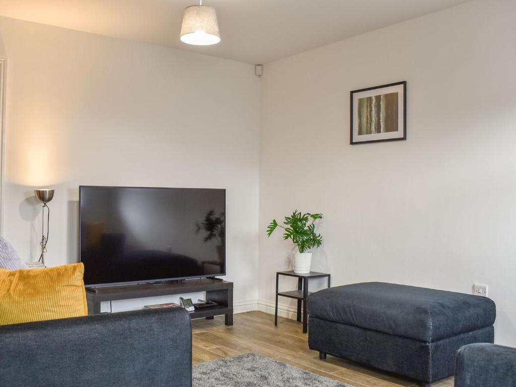 a living room with a large flat screen tv at Pickwood Gatehouse in Leek