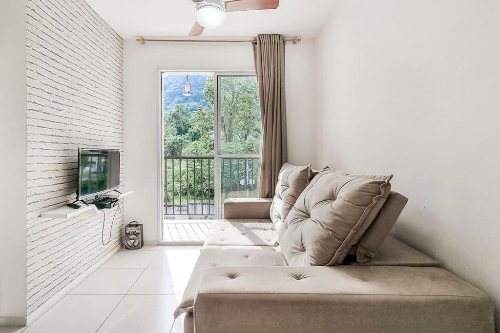 sala de estar con sofá y ventana en Apartamentot perfeito, aconchegante e com Clube, en Río de Janeiro