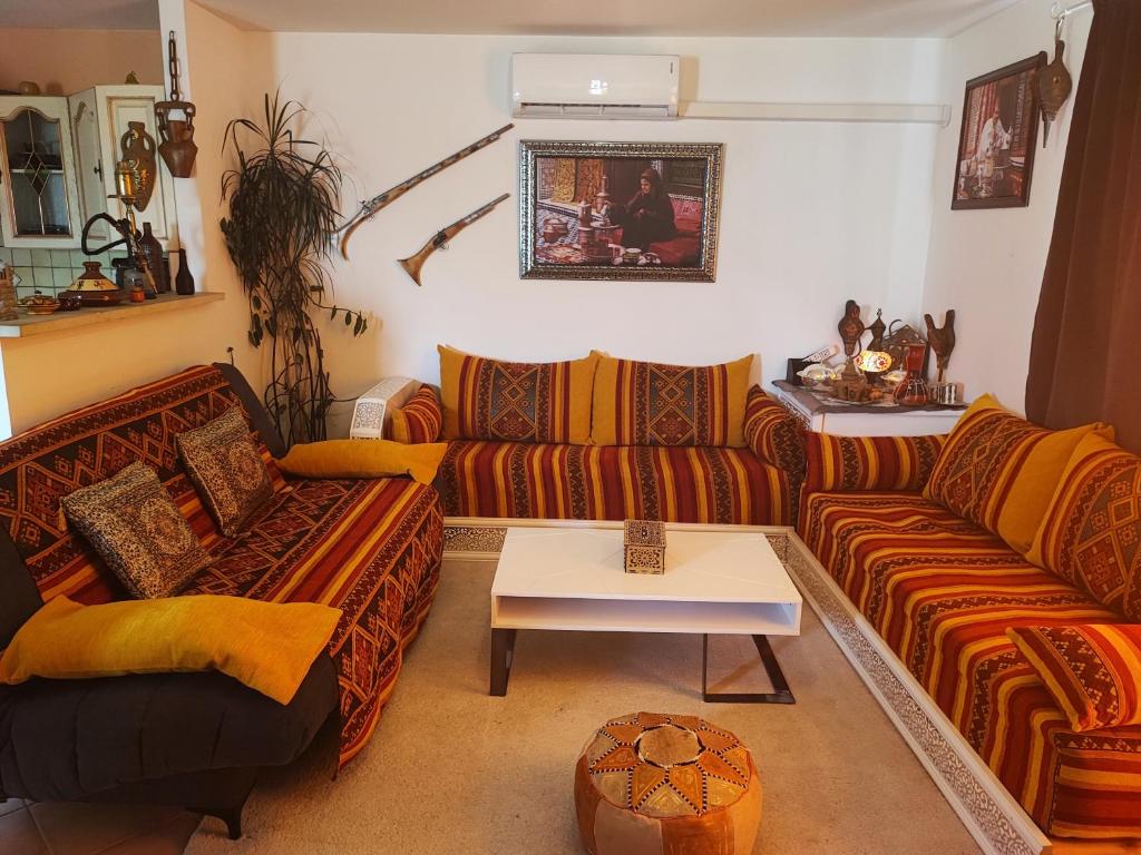 Sala de estar con 2 sofás y mesa en Charmante maison au calme, en Sainte-Maure