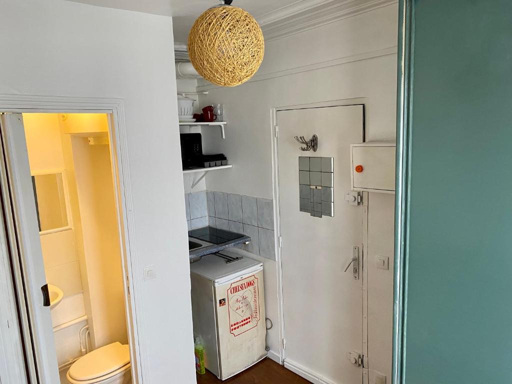 una pequeña cocina con fregadero y nevera. en Home Sweet Home Montmartre Duperre en París