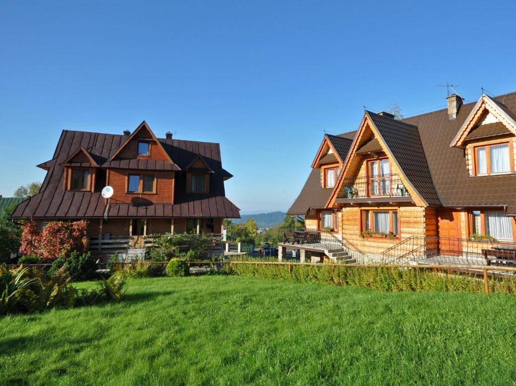 een groot houten huis met een groene tuin bij Willa Marysieńka in Zakopane