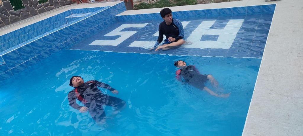 dwóch mężczyzn w wodzie w basenie w obiekcie AFS Suites Barra, Opol w mieście Cagayan de Oro