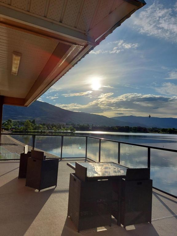 uma varanda com mesa e cadeiras e vista para a água em Richter Pass Beach Resort em Osoyoos