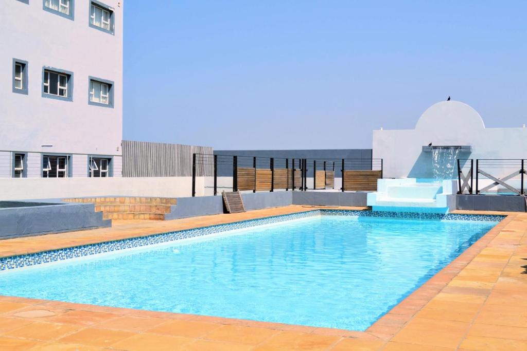 a swimming pool on the roof of a building at Elegant Emerald King Size 2 Bed Apartment - Free Parking - Free Wifi in Durban