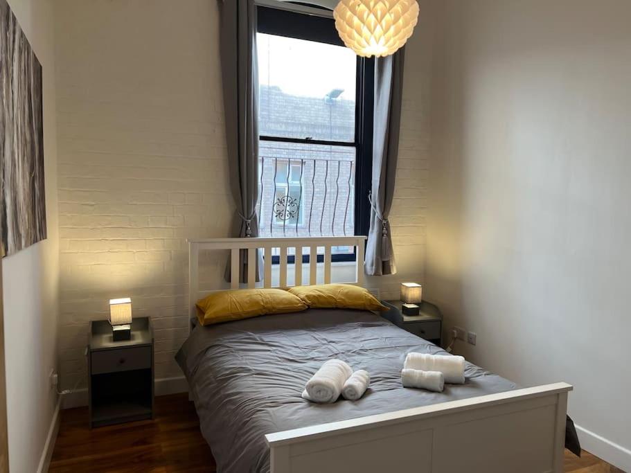 1 dormitorio con 1 cama con 2 toallas en The Dereham - Open Plan Apartment 1 min from the city centre, en Leicester