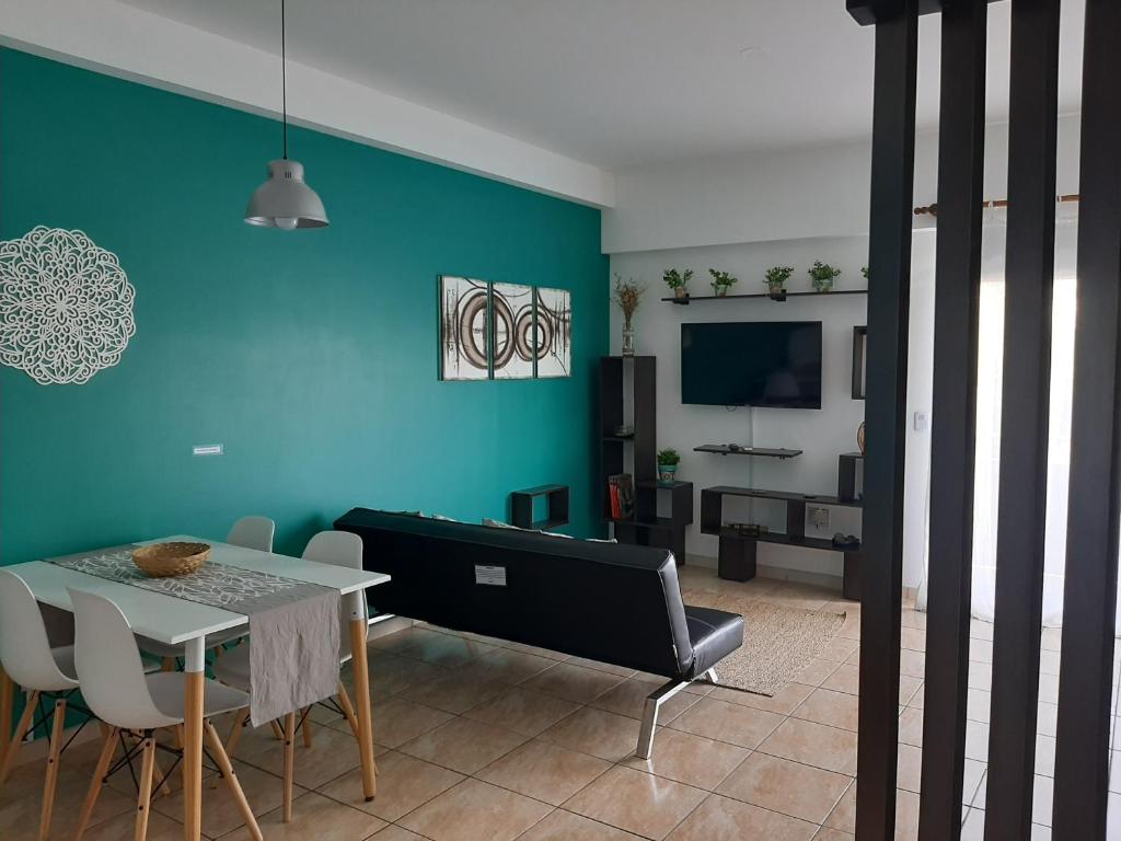 een woonkamer met een tafel en een blauwe muur bij Hermoso departamento en complejo residencial in Tigre