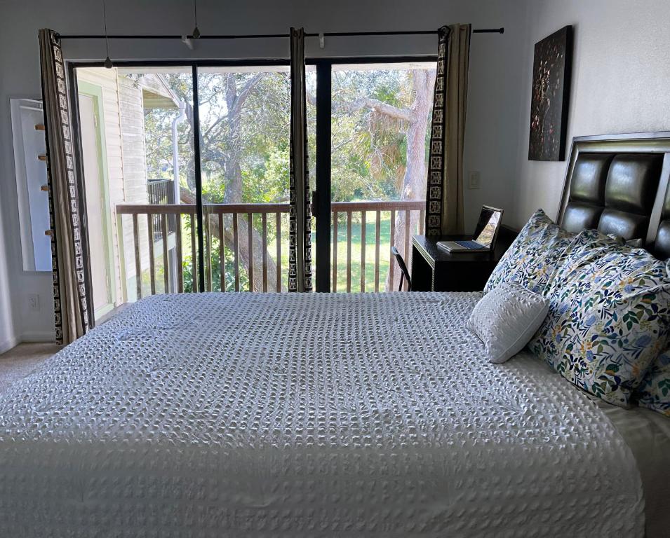 a bedroom with a large bed and a balcony at Hello Sunshine 321... Lift Off in Titusville