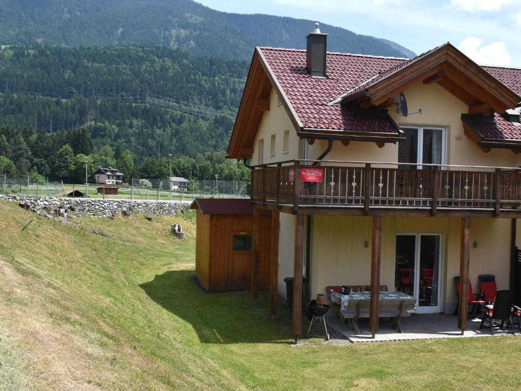 Chalet in Koetschach-Mauthen ski area في كوتسخاخ: منزل مع شرفة على تلة