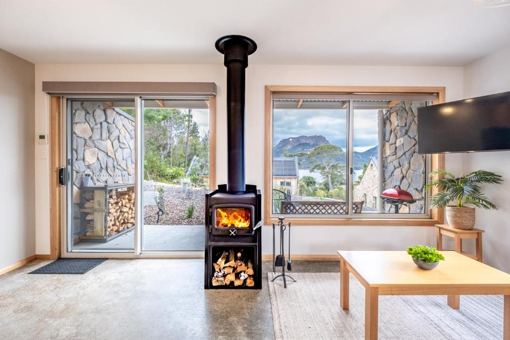 a wood stove in a living room with a window at Freycinet Stone Studio 7 - Quartz in Coles Bay