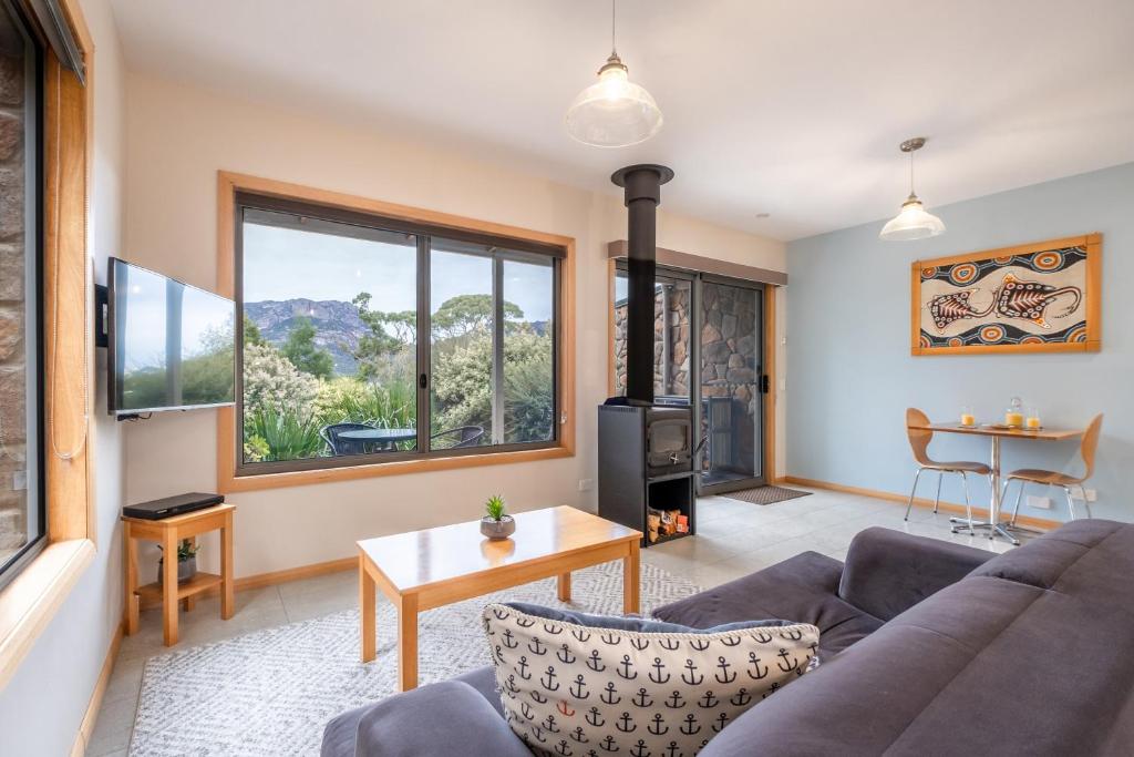 a living room with a couch and a wood stove at Freycinet Stone Studio 6 - Mica in Coles Bay