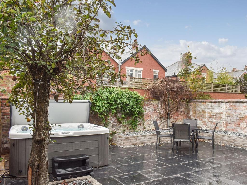 a backyard with a hot tub and a table and chairs at Hampton House in Blackpool