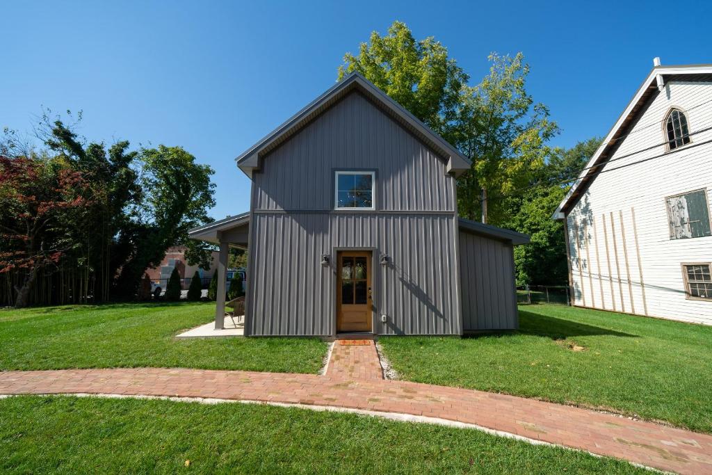 a gray house with a door in a yard at A newly built Tiny House in the center of Historic Kennett Square in Kennett Square