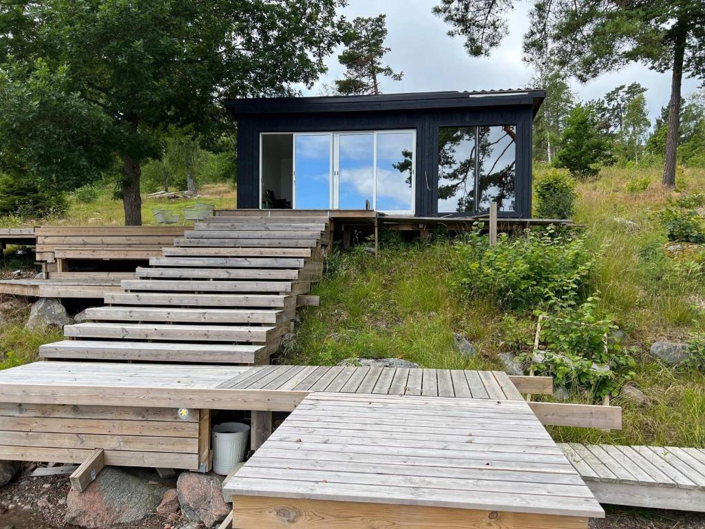 a house on top of a hill with wooden steps at Holiday home VÄDDÖ VI in Väddö