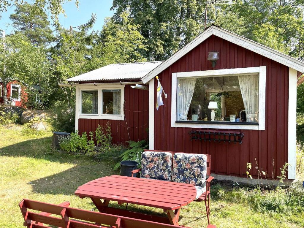 a red shed with a picnic table and a bench at Holiday home VRETA KLOSTER II in Vreta Kloster