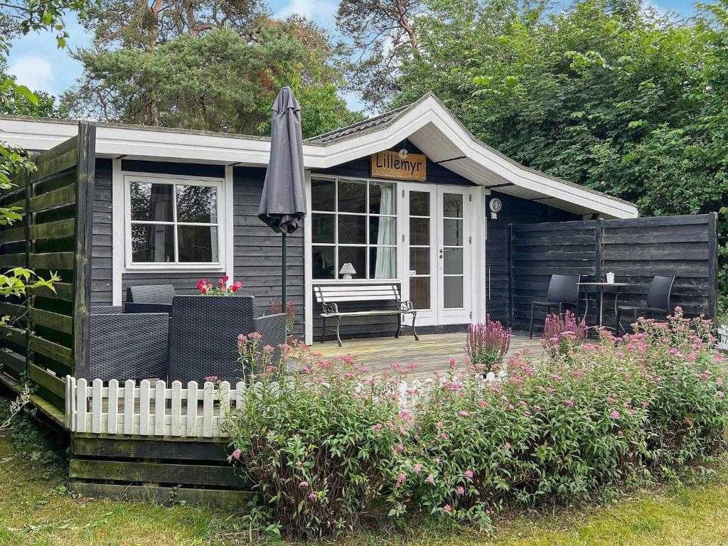 a small house with an umbrella and a patio at Holiday home Nexø XLI in Neksø