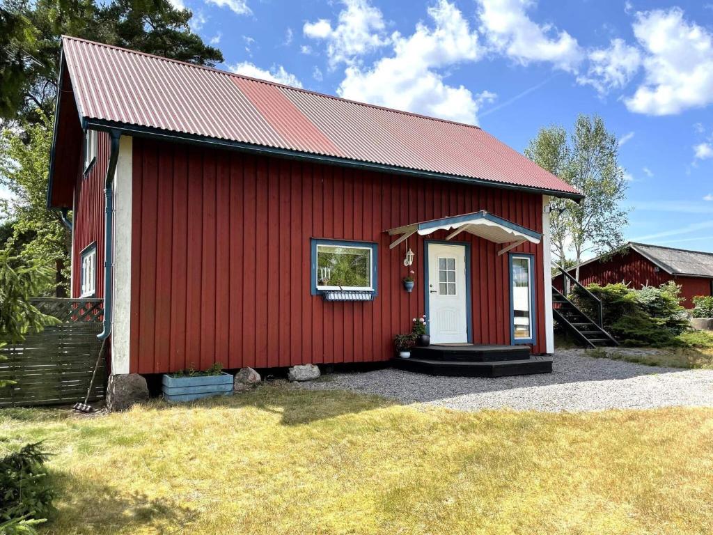 a red barn with a white door and a window at Holiday home GAMLEBY VI in Gamleby