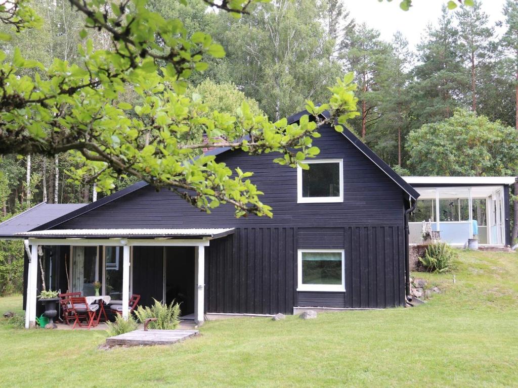 uma casa preta com um alpendre e um quintal em Holiday home SIMLÅNGSDALEN IV em Simlångsdalen