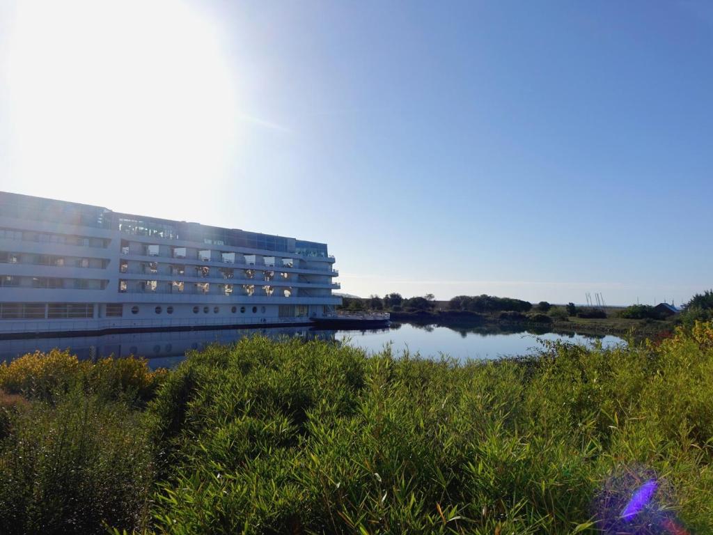 un grand bâtiment à côté d'un plan d'eau dans l'établissement Studio cosy à 5 min du port et de la plage, avec terrasse et parking - 4 pers - FR-1-639-78, à Arzon
