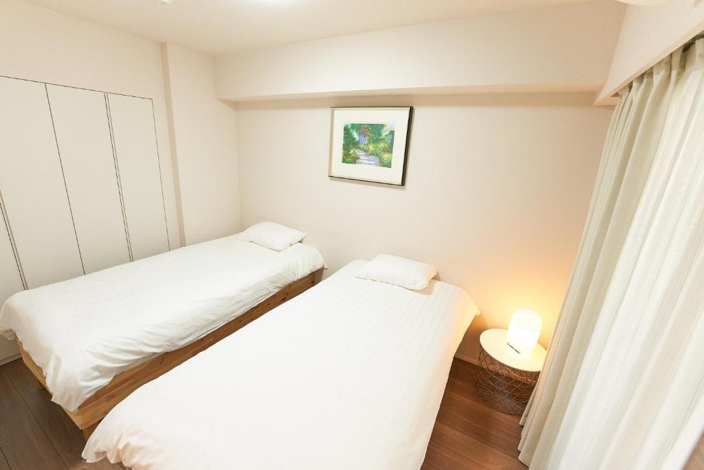 Duas camas num pequeno quarto com uma janela em HIZ HOTEL - Vacation STAY 18549v em Tóquio