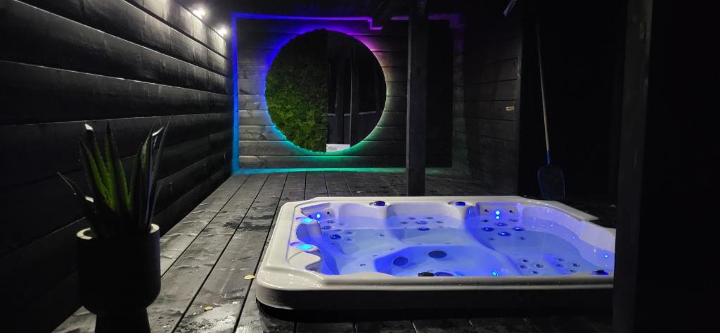 La salle de bains est pourvue d'une baignoire bleue avec une lumière violette. dans l'établissement Fabryka Snów loft w sercu Beskidów, à Istebna