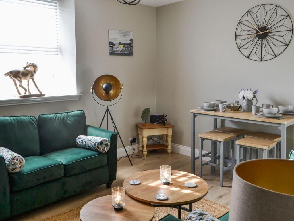 Dove Cottage-number 16 في بلفورد: غرفة معيشة مع أريكة خضراء وطاولة