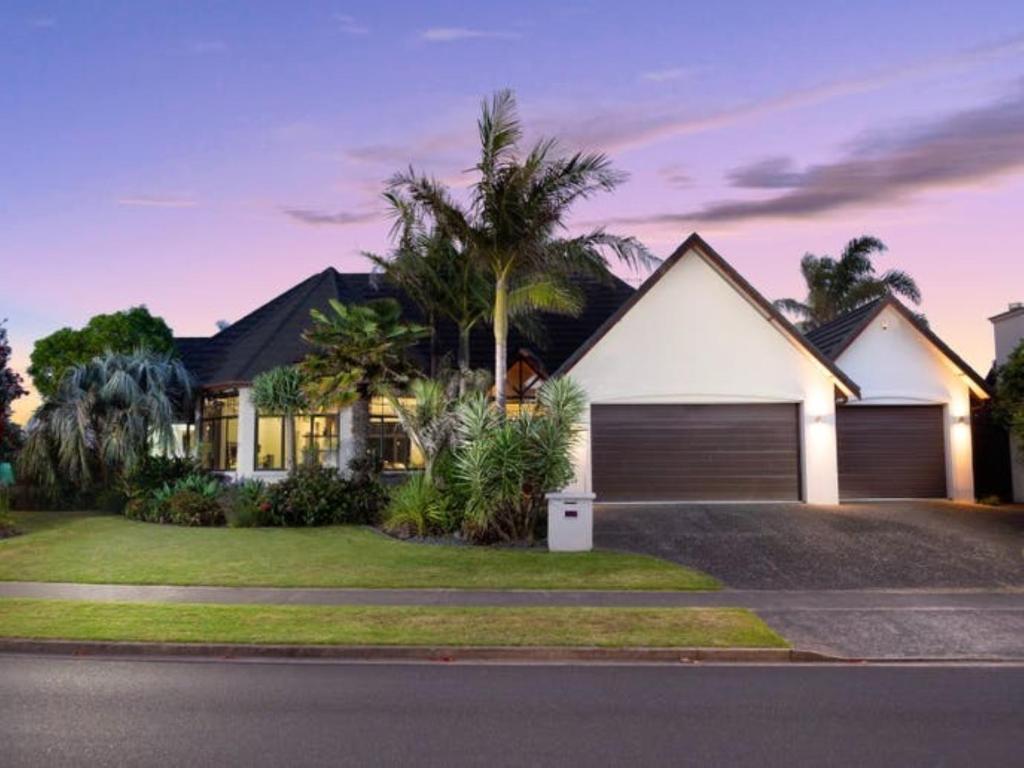a house with a garage in front of it at Palm Paradise in Tauranga