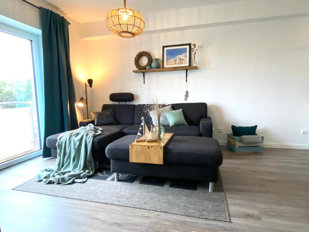 een woonkamer met een bank en een tafel bij Beach54 Damp Wellness-Loft in Damp