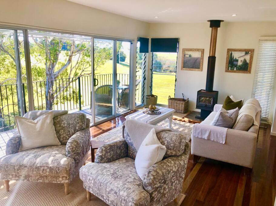 a living room with two couches and a fireplace at "La Petite Grange" Maleny in Maleny