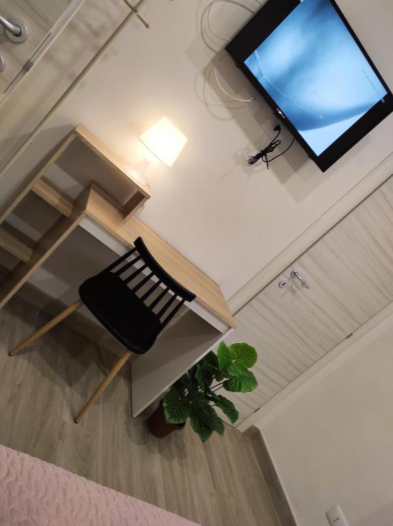 nad głową pokoju z krzesłem i telewizorem w obiekcie HOME DOLCE LUNA w mieście Castelvetrano Selinunte