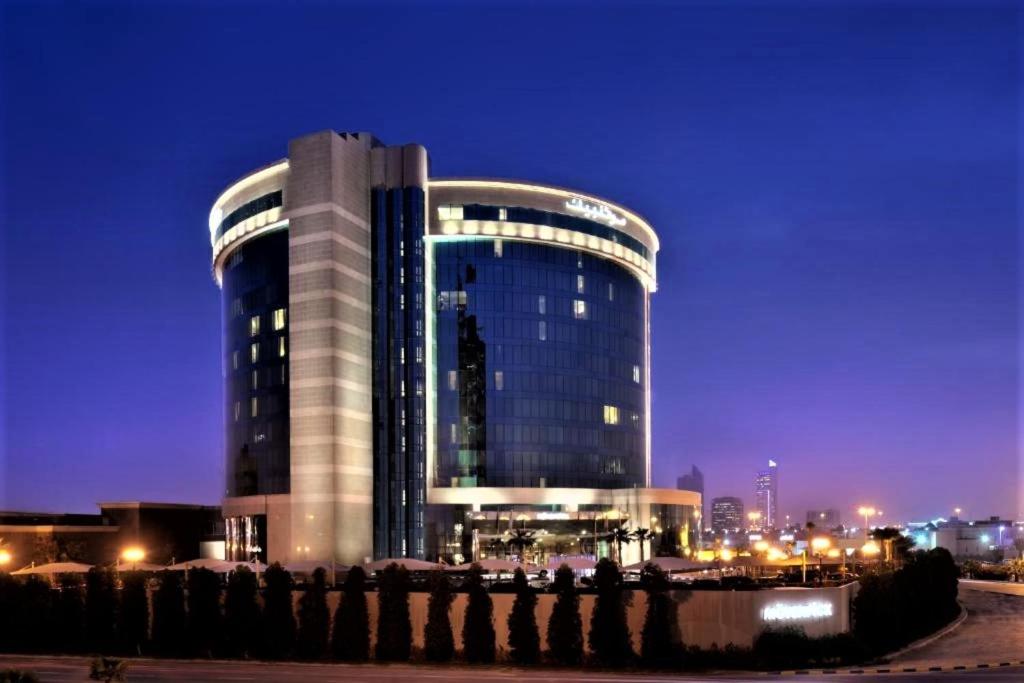a large building with a lot of windows at night at Mövenpick Hotel Al Khobar in Al Khobar