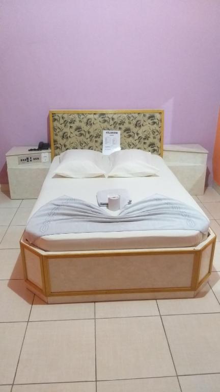 Una cama en un dormitorio con un cartel. en Hotel bom retiro en São Paulo