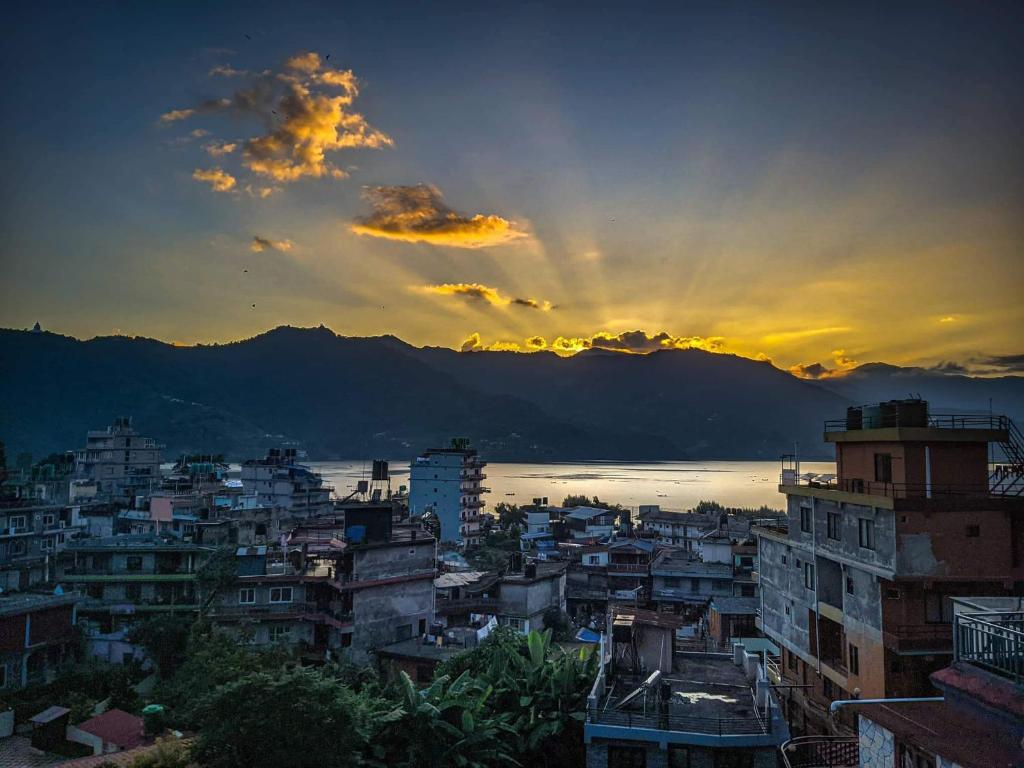a view of a city with a sunset in the background at Beli Guest House in Pokhara