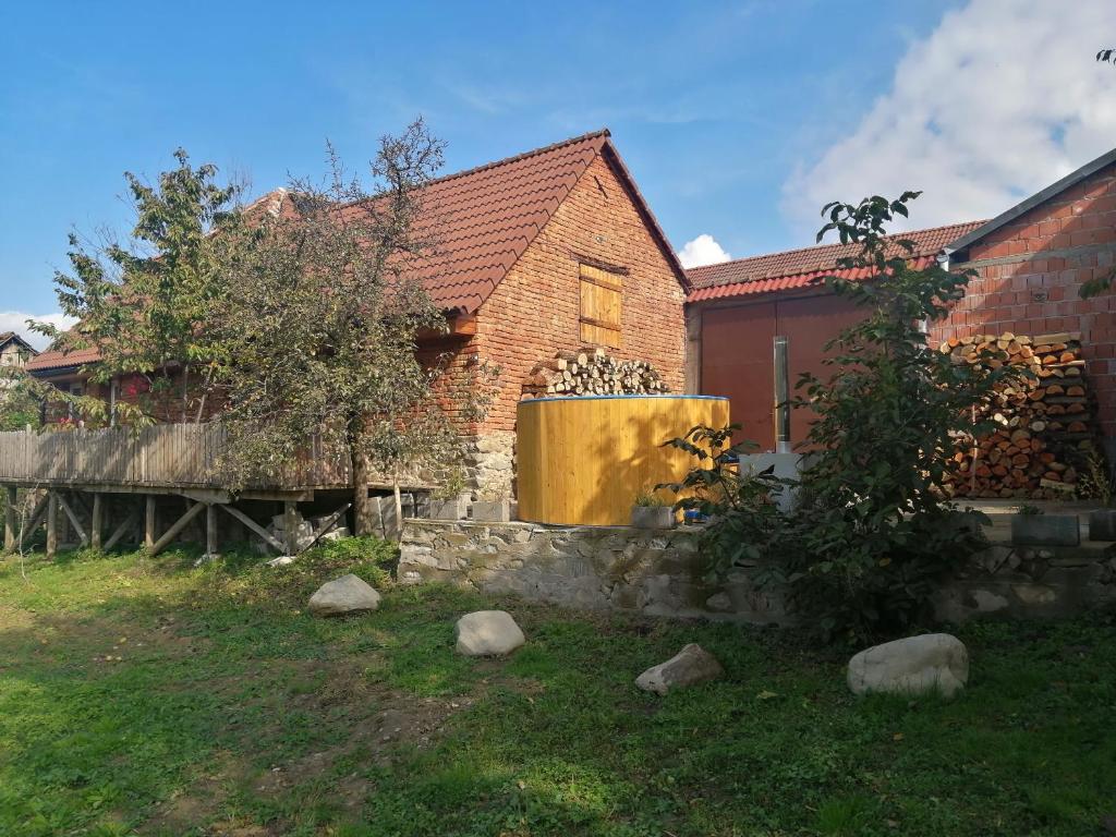 a brick house with a tree and a building at Borlova /Muntele Mic in Borlova