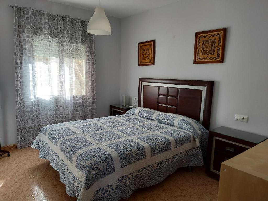 Schlafzimmer mit einem Bett und einem Fenster in der Unterkunft Corazón de Aguilar in Aguilar de la Frontera