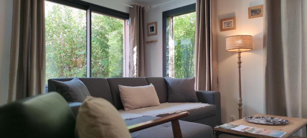 a living room with a couch and a large window at Gîte le 54 in Saint-Quentin-en-Tourmont