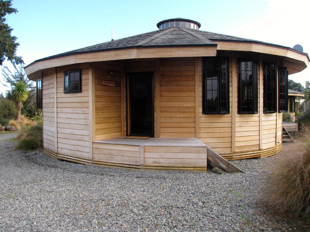 a large wooden building with a porch on top at Ngauruhoe Yurt - Ohakune Holiday Home in Ohakune