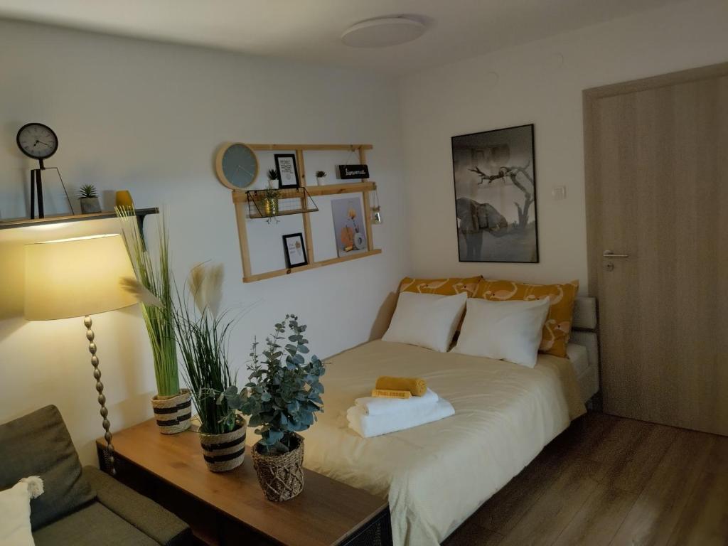 um quarto com uma cama e uma mesa com um candeeiro em Apartman 7th Heaven em Zagreb