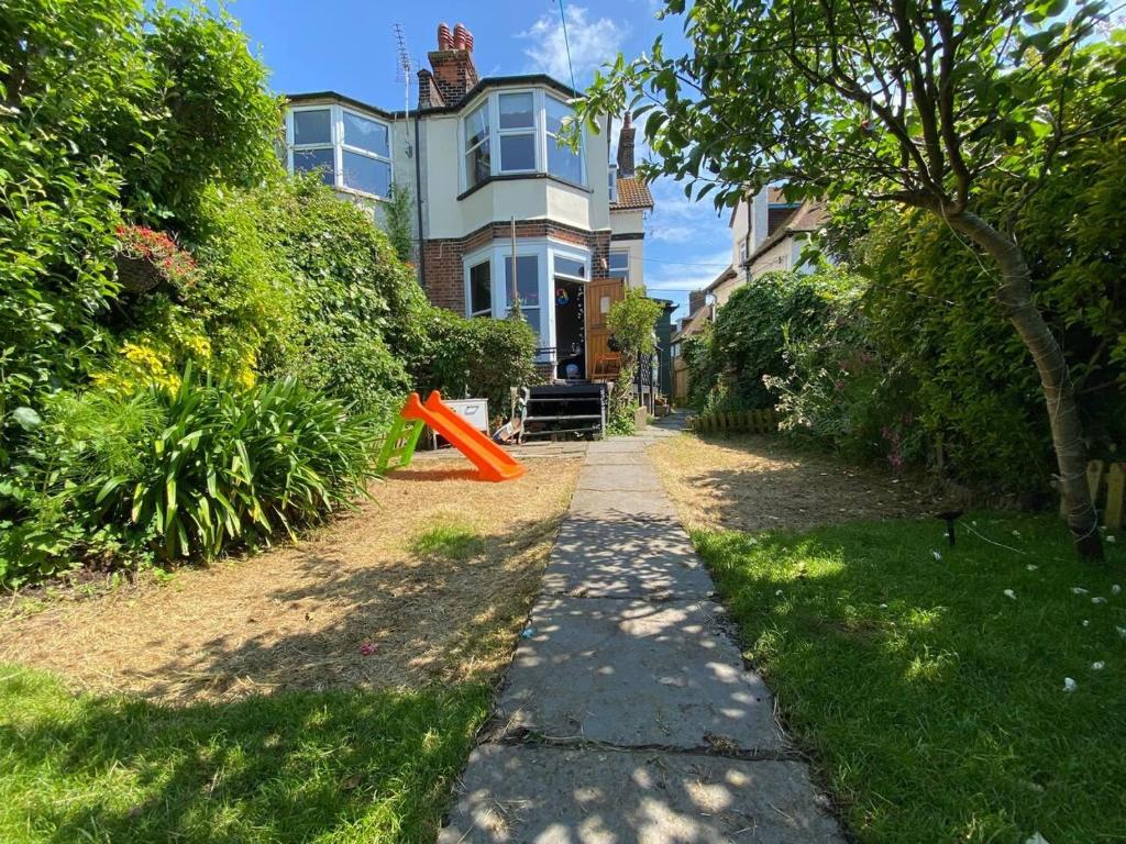 a sidewalk in front of a house with an orange object at Edwardian Villa by the Sea Coastal Walks King Beds in Walton-on-the-Naze