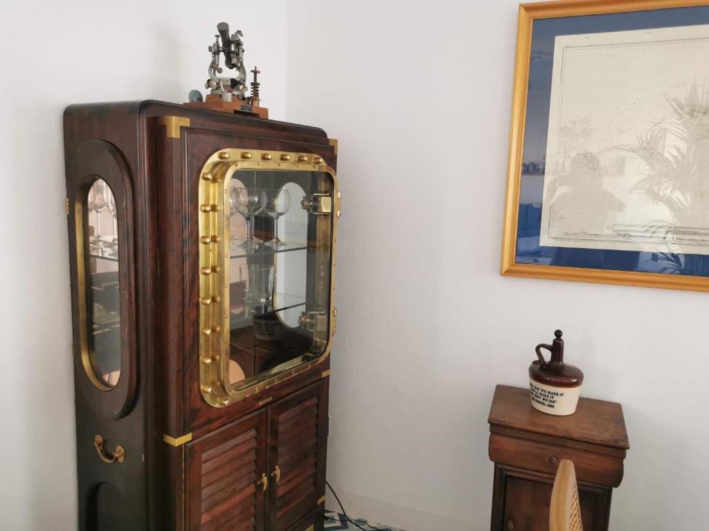 an old grandfather clock sitting next to a wall at ABA DALÍ in Conil de la Frontera
