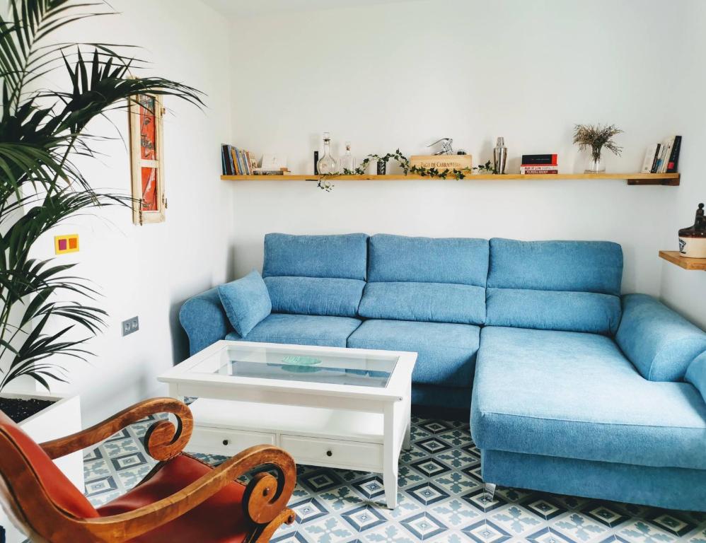 a living room with a blue couch and a table at ABA DALÍ in Conil de la Frontera