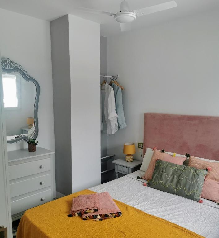 a bedroom with a bed with a yellow blanket on it at ABA DALÍ in Conil de la Frontera