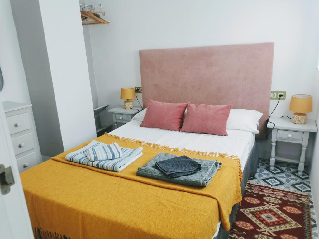 a bedroom with a bed with two pillows on it at ABA DALÍ in Conil de la Frontera