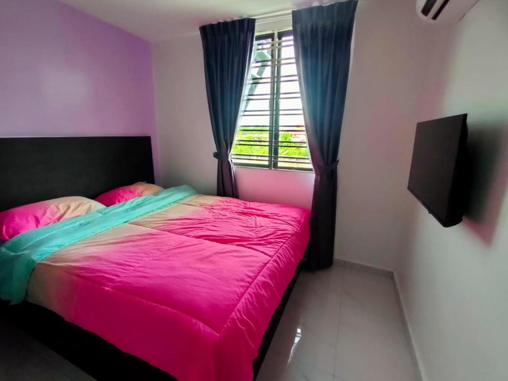 sypialnia z różowym łóżkiem i oknem w obiekcie HOTEL Benut w mieście Kampong Parit Tengah