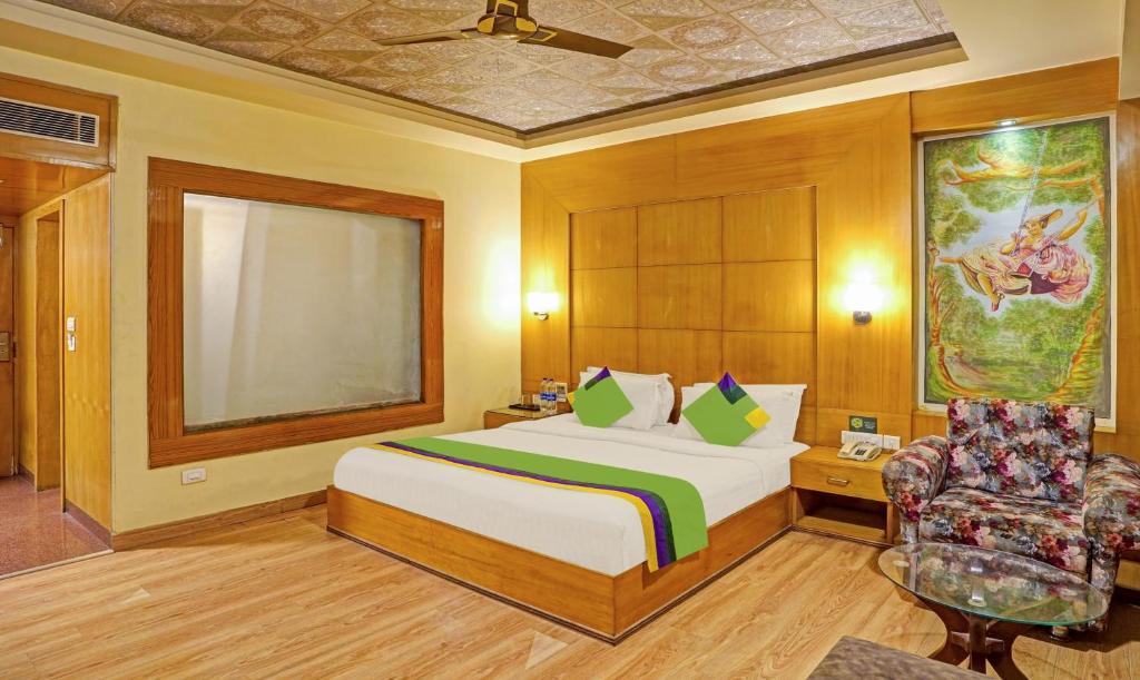 una camera d'albergo con letto e sedia di Treebo Trend The Royal CM - 4 Km From City Palace a Jaipur