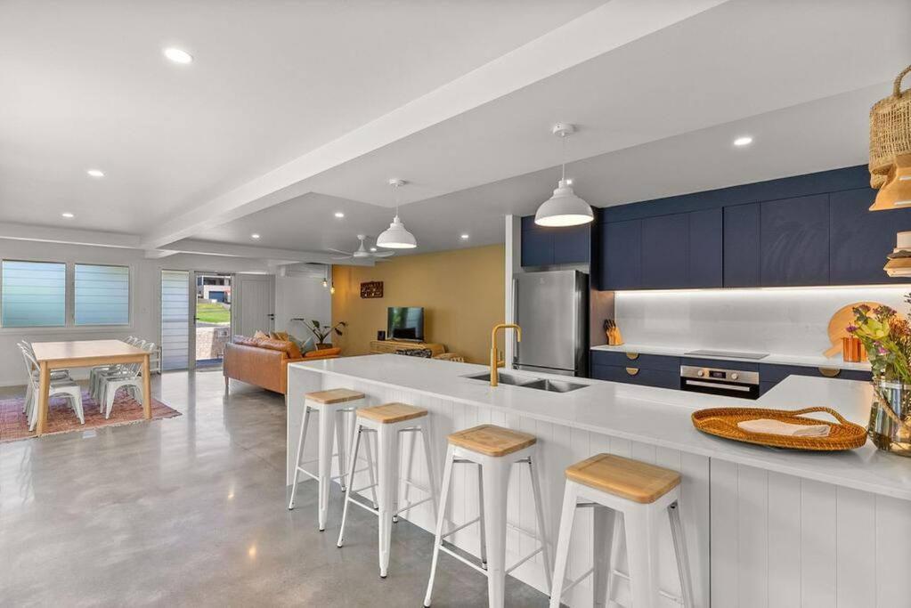a kitchen with a counter and some stools in it at Salty Crab Bungalow in Lennox Head