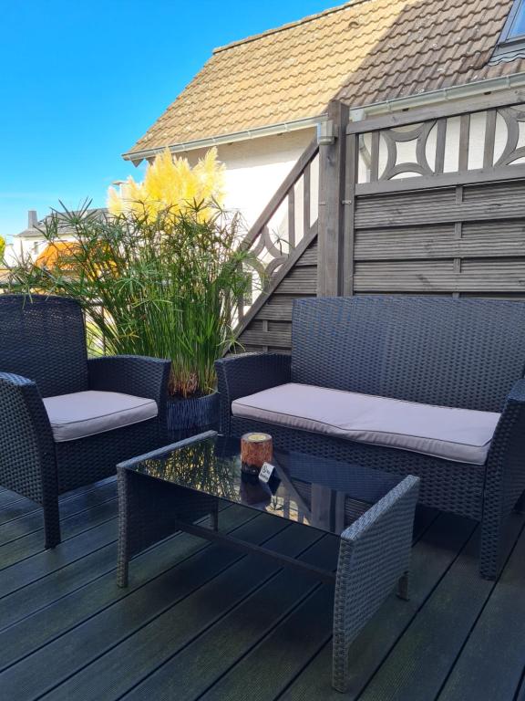 a patio with two chairs and a table on a deck at Ferienwohnung in Fuldatal bei Kassel in Fuldatal